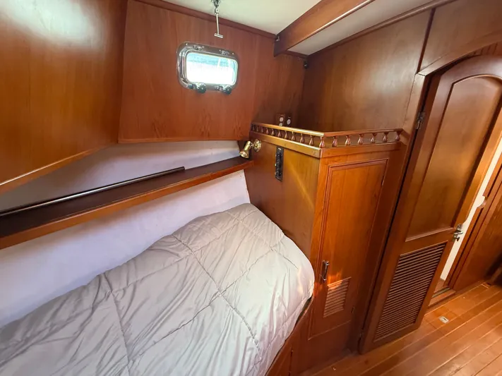 Aja Marie Yacht Photos Pics 1986 Marine Trader Tri Cabin interior with wooden paneling and cozy bed.