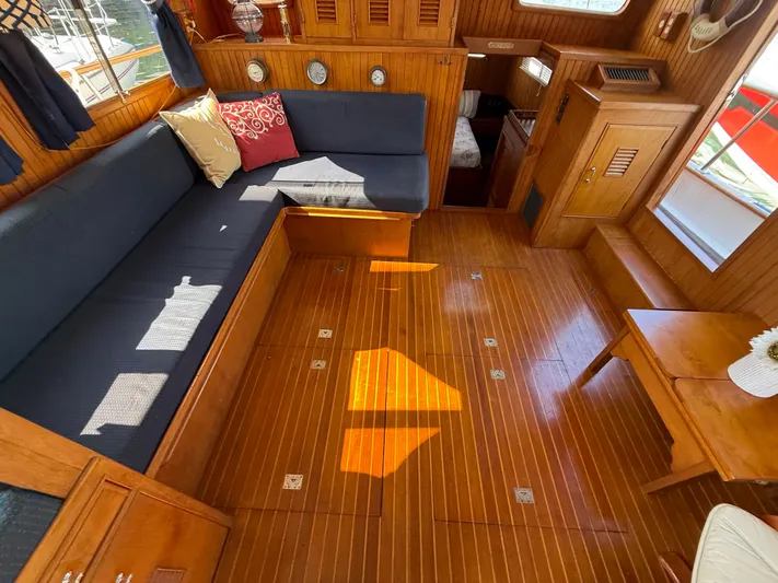 Aja Marie Yacht Photos Pics 1986 Marine Trader Tri Cabin interior with wooden flooring, cozy seating, and nautical decor.