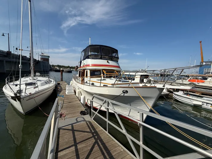 Aja Marie Yacht Photos Pics 1986 Marine Trader Tri Cabin yacht docked at a marina under a clear blue sky.