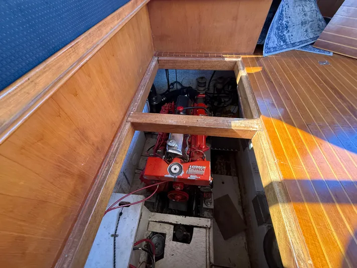 Aja Marie Yacht Photos Pics 1986 Marine Trader Tri Cabin engine compartment with visible red engine and wooden flooring.