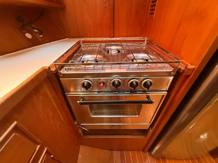 Aja Marie Yacht Photos Pics 1986 Marine Trader Tri Cabin kitchen with stainless steel stove and wooden cabinetry.