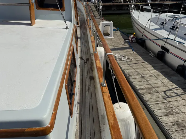 Aja Marie Yacht Photos Pics 1986 Marine Trader Tri Cabin docked, showcasing wooden railings and deck details.