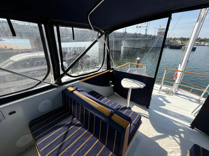 Aja Marie Yacht Photos Pics 1986 Marine Trader Tri Cabin interior with striped seating, table, and waterfront view.