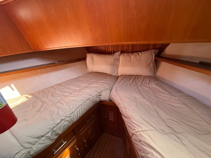 Aja Marie Yacht Photos Pics Cozy cabin interior of 1986 Marine Trader Tri Cabin with twin beds and wooden finish.