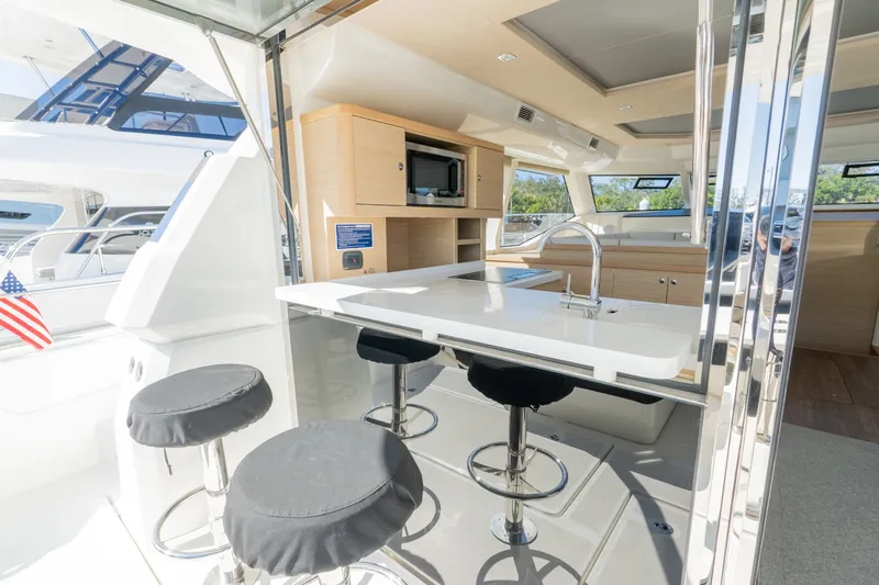  Yacht Photos Pics Interior of 2023 Aquila 44 Yacht featuring modern kitchen and bar stools.