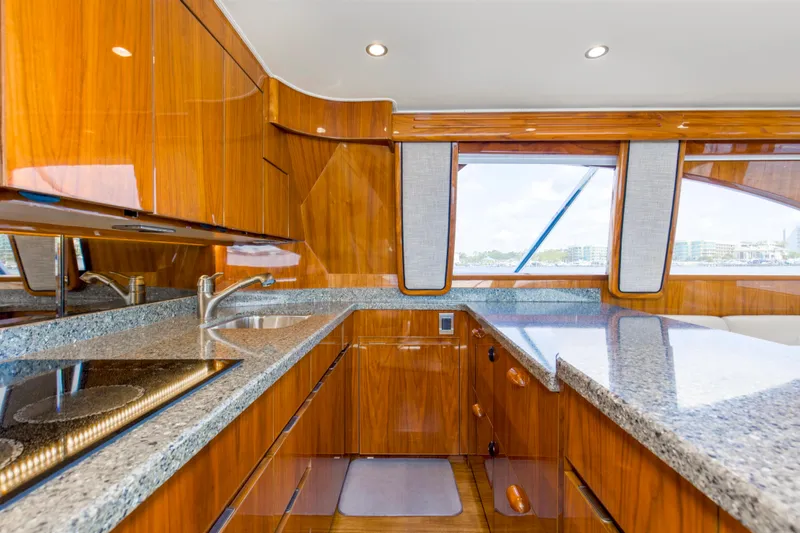 Reel Petty Yacht Photos Pics Luxurious kitchen interior of 2017 Viking 48 Convertible yacht with wood cabinetry and granite countertops.