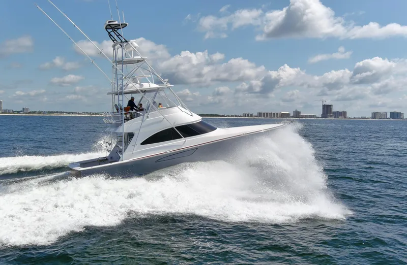 Reel Petty Yacht Photos Pics 2017 Viking 48 Convertible yacht cruising on open water under a partly cloudy sky.