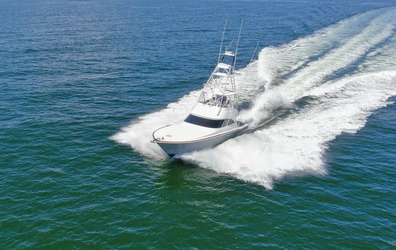 Reel Petty Yacht Photos Pics 2017 Viking 48 Convertible yacht cruising swiftly on open water.