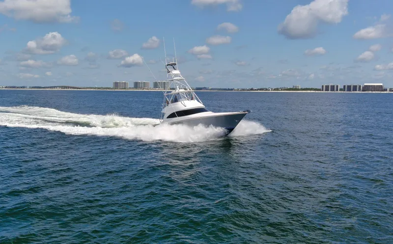 Reel Petty Yacht Photos Pics 2017 Viking 48 Convertible yacht cruising on open water under a clear blue sky.