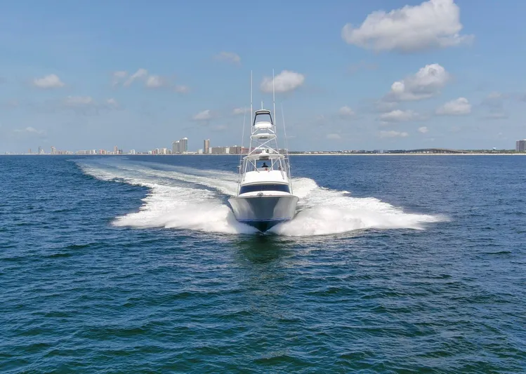 Reel Petty Yacht Photos Pics 2017 Viking 48 Convertible yacht cruising on open water under a clear blue sky.
