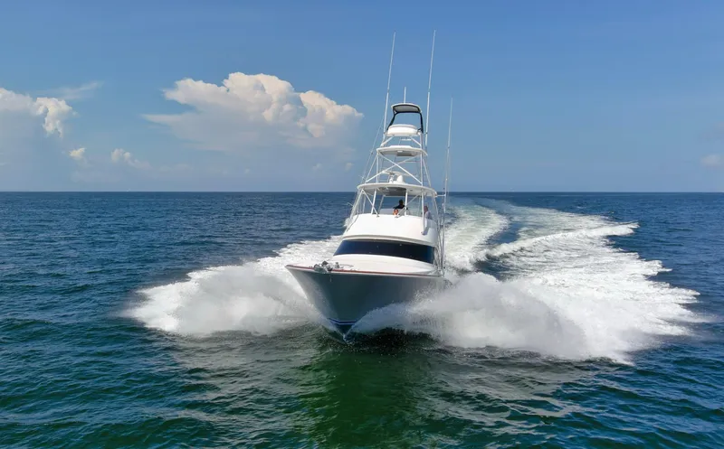 Reel Petty Yacht Photos Pics 2017 Viking 48 Convertible yacht cruising on open sea under clear blue sky.