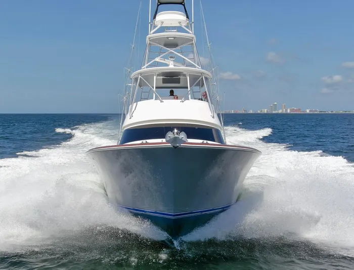 Reel Petty Yacht Photos Pics 2017 Viking 48 Convertible yacht cruising on open water, city skyline in background.