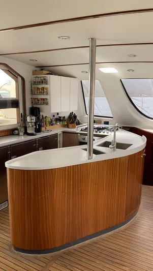 Mersea Yacht Photos Pics Spacious kitchen interior of 2001 Catana 582 yacht with modern amenities and wooden finishes.