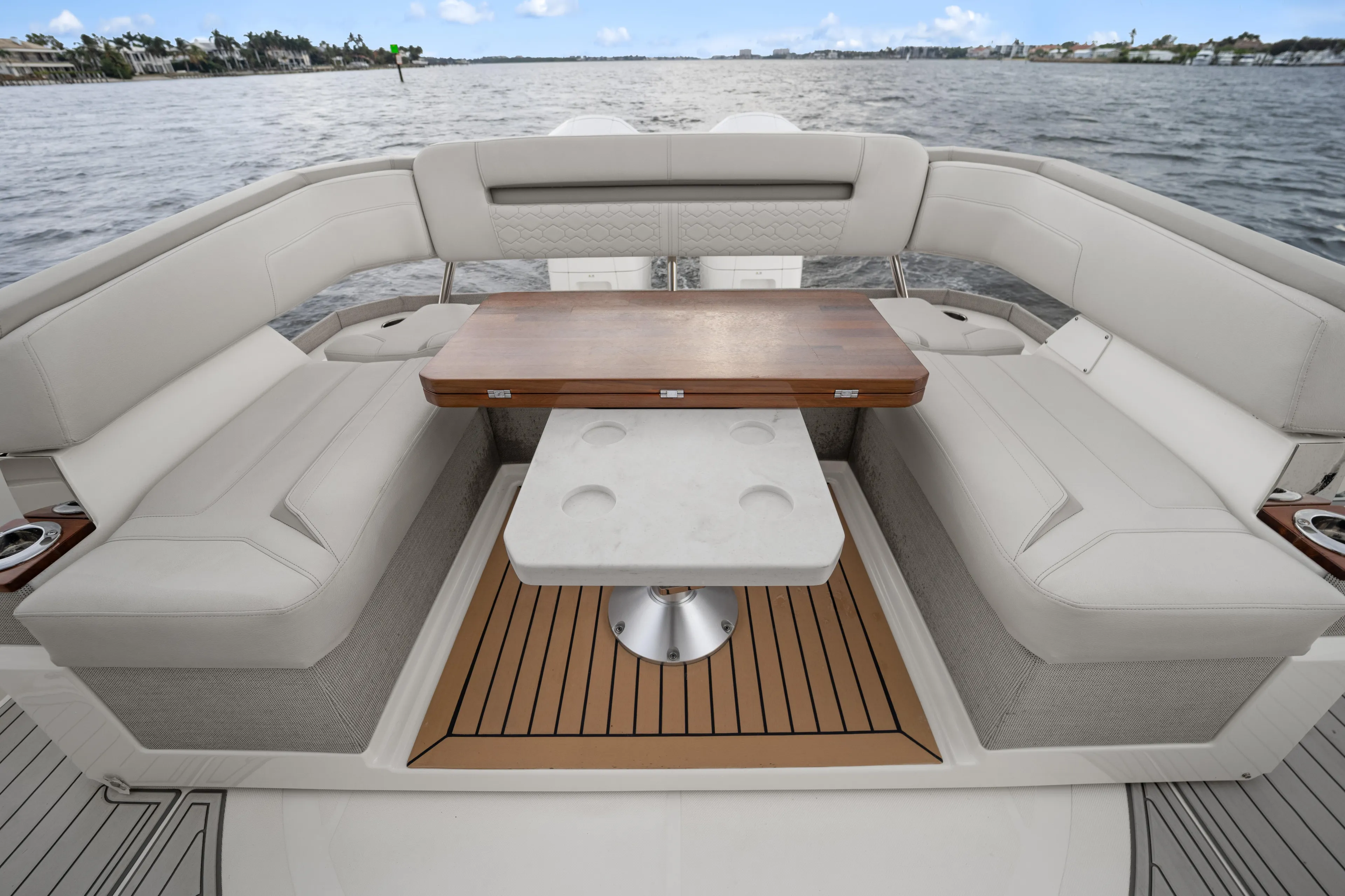 Twelve Yacht Photos Pics Luxury seating area on 2022 Tiara Sport 43 LS boat with elegant table and scenic water view.