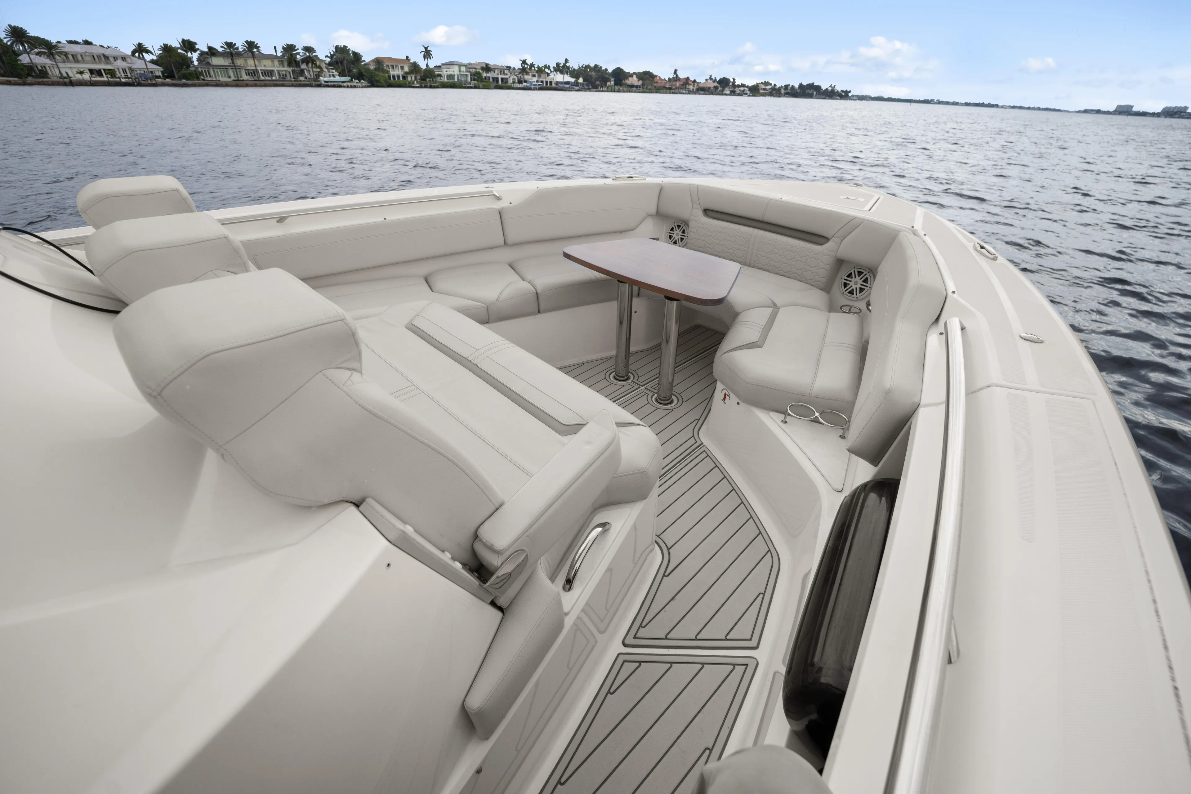 Twelve Yacht Photos Pics 2022 Tiara Sport 43 LS boat interior with luxurious seating and table on calm water.