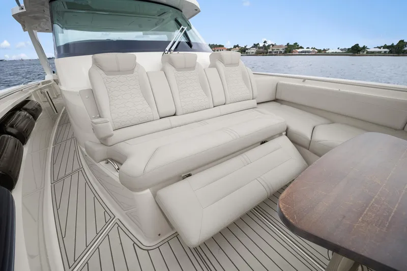 Twelve Yacht Photos Pics 2022 Tiara Sport 43 LS luxury boat interior with plush seating and wooden table.