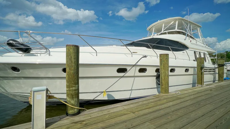 Laurie Lu Yacht Photos Pics Luxury 2002 Viking Princess 68 yacht docked under a clear blue sky.