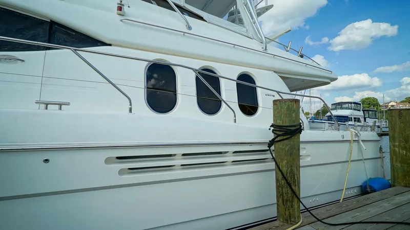 Laurie Lu Yacht Photos Pics Luxury yacht Viking Princess 68, 2002 model, docked at marina under blue sky.