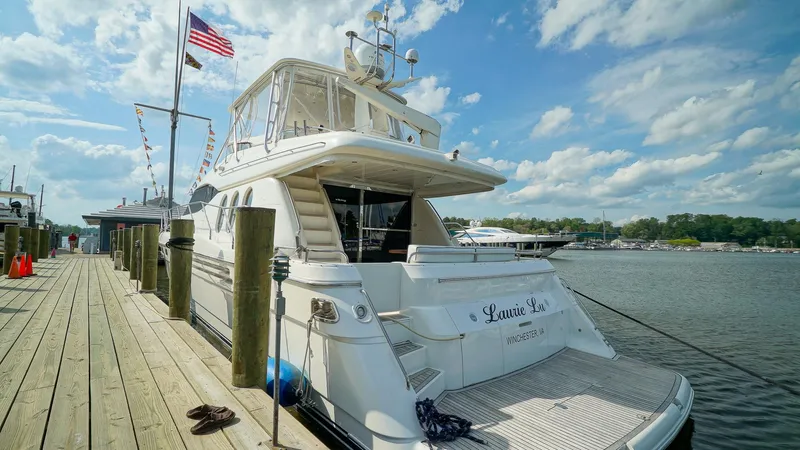 Laurie Lu Yacht Photos Pics Luxury yacht Viking Princess 68, 2002 model, docked at marina under blue sky.