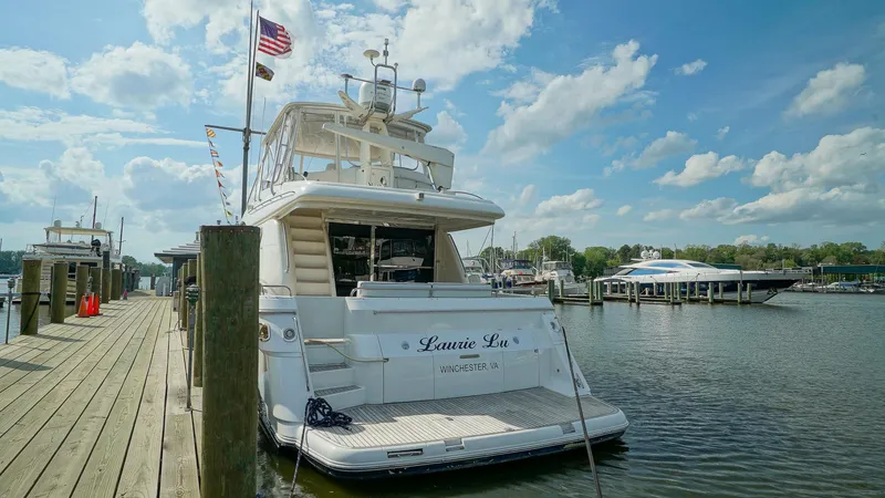 Laurie Lu Yacht Photos Pics Luxury yacht Viking Princess 68, 2002 model, docked at a marina under a blue sky.