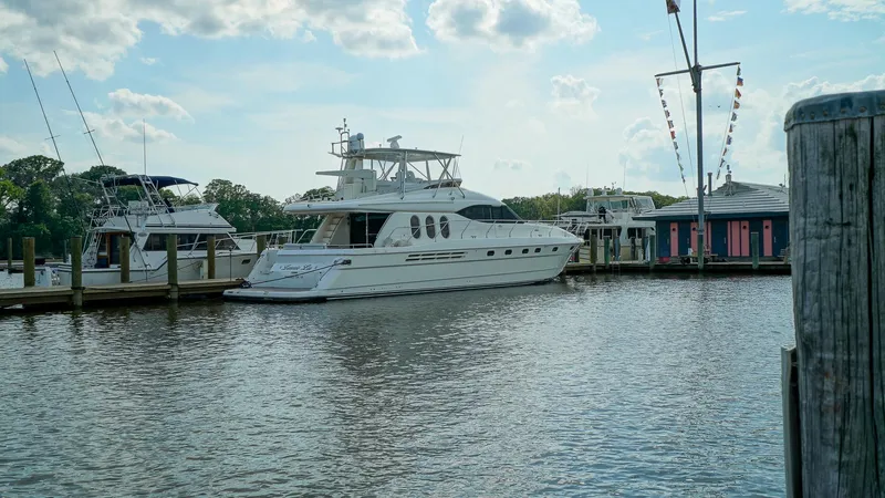 Laurie Lu Yacht Photos Pics Luxury Viking Princess 68 yacht docked at marina, 2002 model, under a partly cloudy sky.