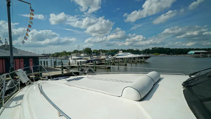 Laurie Lu Yacht Photos Pics Luxury yacht Viking Princess 68, 2002 model, docked at a marina under a partly cloudy sky.