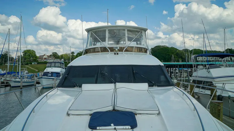 Laurie Lu Yacht Photos Pics Luxury Viking Princess 68 yacht docked at marina, 2002 model, under a partly cloudy sky.