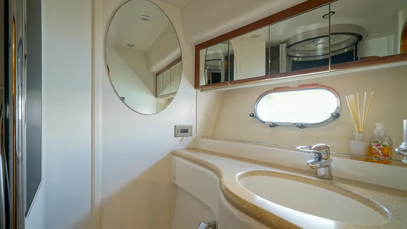 Laurie Lu Yacht Photos Pics Luxurious bathroom in 2002 Viking Princess 68 yacht with oval mirror and porthole window.