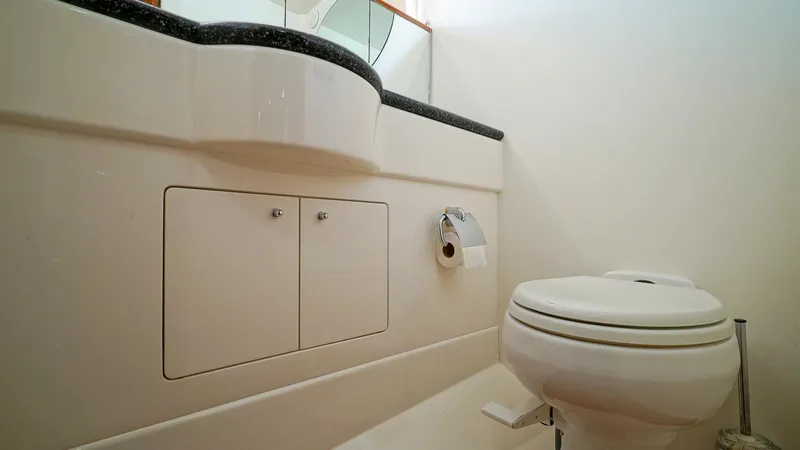 Laurie Lu Yacht Photos Pics Bathroom interior of 2002 Viking Princess 68 yacht, featuring toilet and vanity.