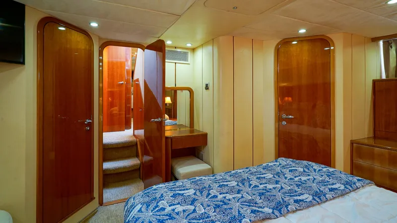 Laurie Lu Yacht Photos Pics Luxurious cabin interior of 2002 Viking Princess 68 Sport Cruiser with wood finishes and blue bedding.