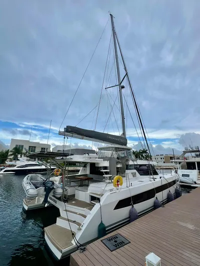 Win Win Yacht Photos Pics 2022 Leopard 50 catamaran docked at marina under cloudy sky.