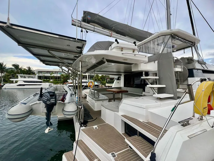 Win Win Yacht Photos Pics Modern Leopard 50 catamaran, 2022 model, docked with open deck and tender boat.