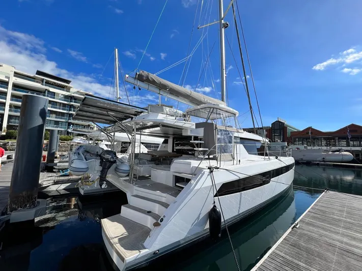 Win Win Yacht Photos Pics Modern 2022 Leopard 50 catamaran docked at marina under clear blue sky.