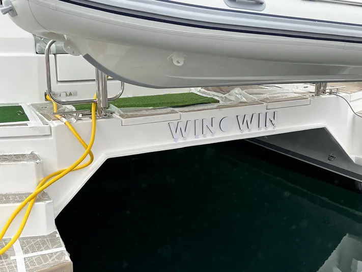 Win Win Yacht Photos Pics Leopard 50 yacht with "WINC WIN" name, docked, featuring a tender and yellow cable.