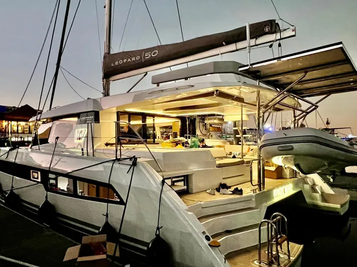 Win Win Yacht Photos Pics Luxurious 2022 Leopard 50 yacht illuminated at dusk, showcasing elegant design and spacious deck.