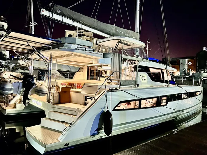 Win Win Yacht Photos Pics 2022 Leopard 50 catamaran docked at night, illuminated interior, sleek design.