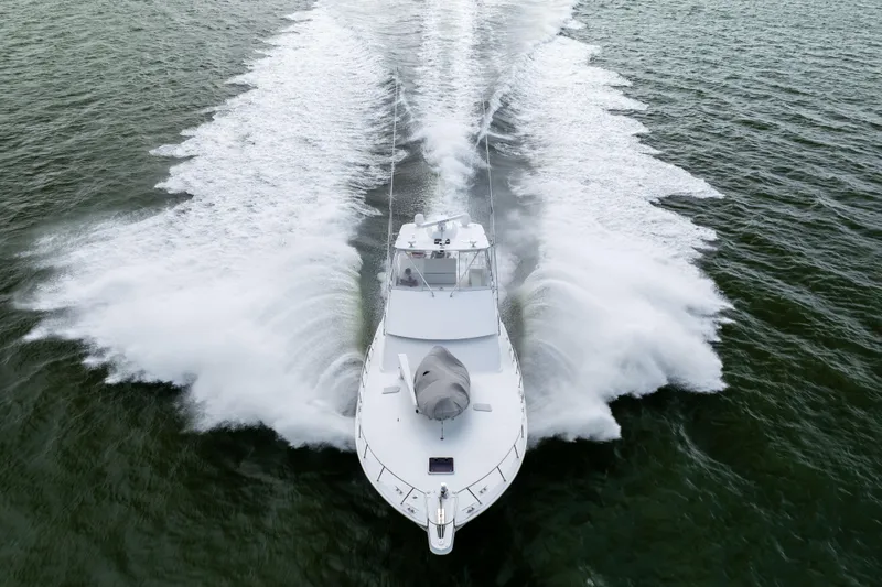 Wet Hooker Yacht Photos Pics 2003 Hatteras 60 Convertible yacht cruising swiftly on open water.