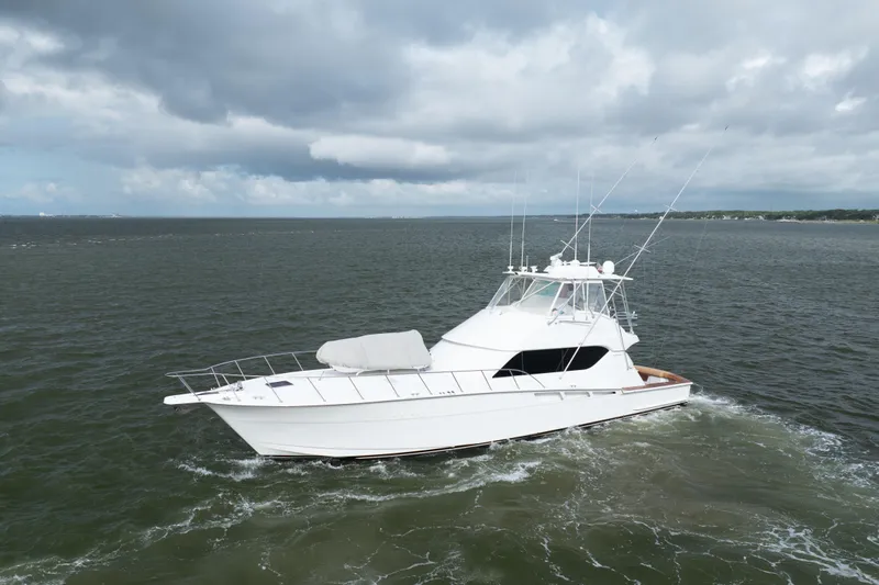 Wet Hooker Yacht Photos Pics 2003 Hatteras 60 Convertible yacht cruising on open water under cloudy skies.