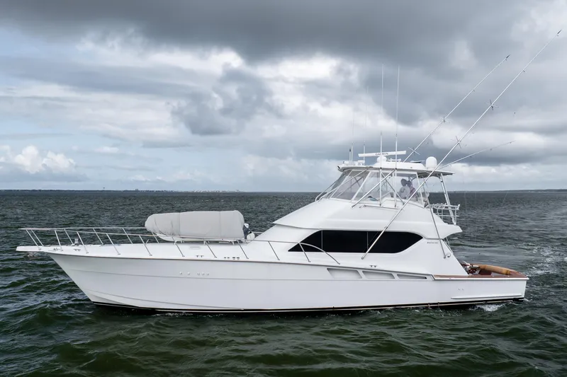 Wet Hooker Yacht Photos Pics 2003 Hatteras 60 Convertible yacht cruising on open water under cloudy skies.