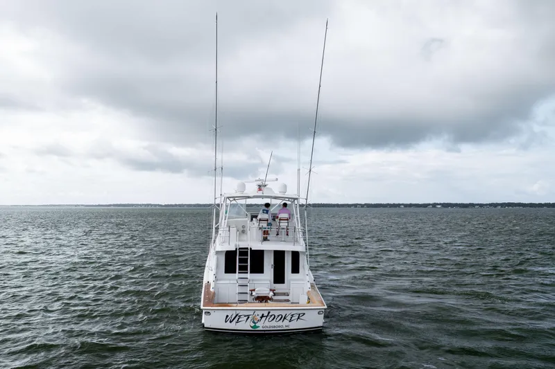 Wet Hooker Yacht Photos Pics 2003 Hatteras 60 Convertible yacht on open water under cloudy skies.
