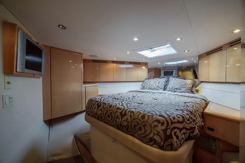 Wet Hooker Yacht Photos Pics Luxurious bedroom interior of 2003 Hatteras 60 Convertible yacht with elegant bedding and wood cabinetry.