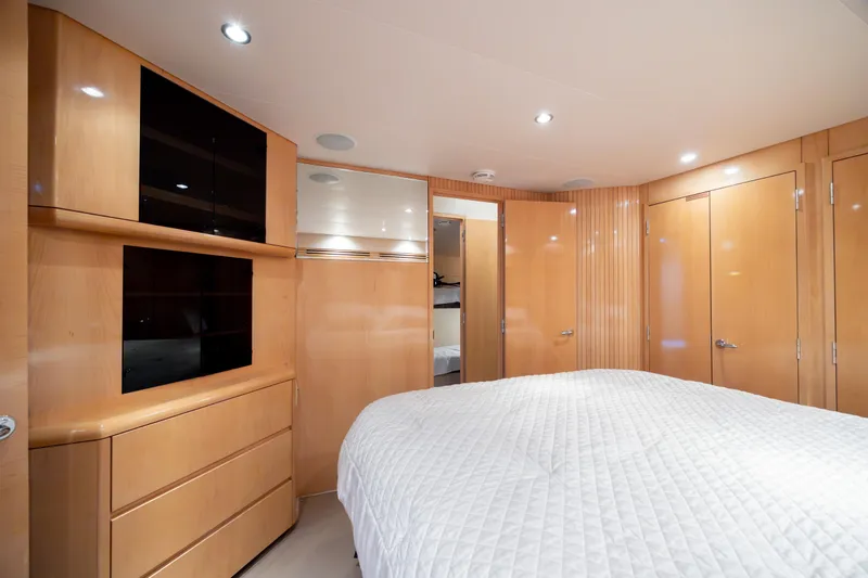 Wet Hooker Yacht Photos Pics Luxurious cabin interior of 2003 Hatteras 60 Convertible yacht with wood paneling and cozy bedding.