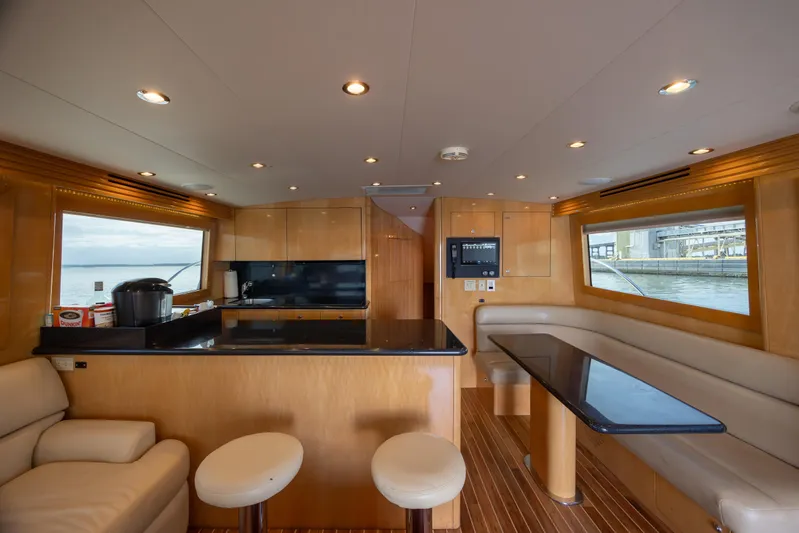 Wet Hooker Yacht Photos Pics Luxurious interior of 2003 Hatteras 60 Convertible yacht with modern kitchen and seating area.