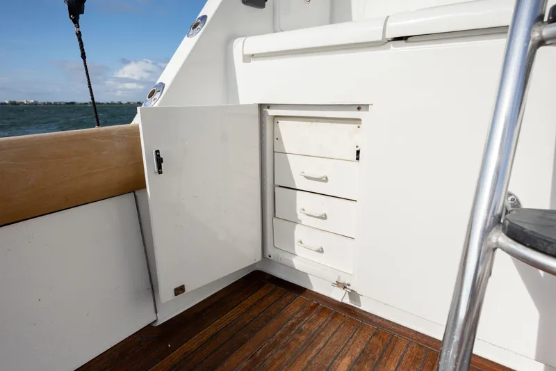 Wet Hooker Yacht Photos Pics 2003 Hatteras 60 Convertible yacht interior with open storage cabinet and wooden deck.