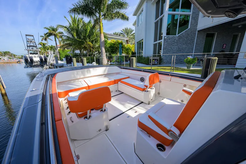  Yacht Photos Pics 2022 World Cat 400 CC-X boat with orange seating, docked near a modern waterfront home.
