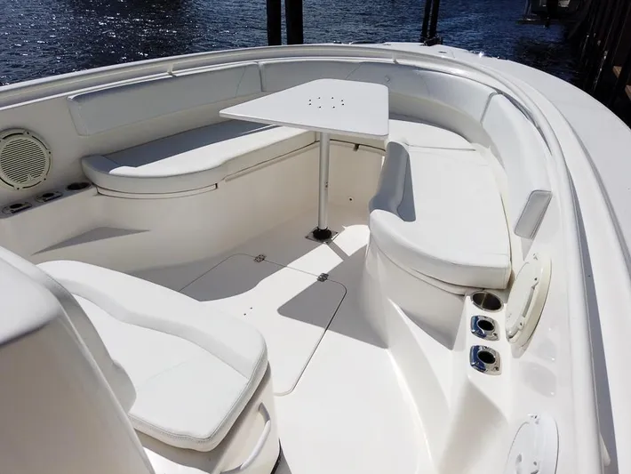  Yacht Photos Pics 2015 Edgewater 320CC boat interior with white seating and table, docked by the water.