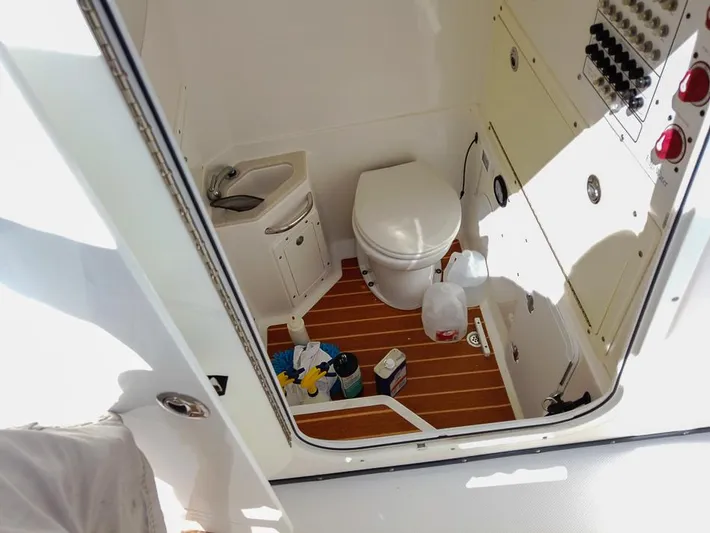  Yacht Photos Pics Interior of 2015 Edgewater 320CC boat bathroom with toilet, sink, and cleaning supplies.