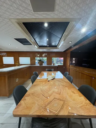  Yacht Photos Pics Luxurious interior of 2000 Baglietto 116 yacht with elegant dining area and wooden table.