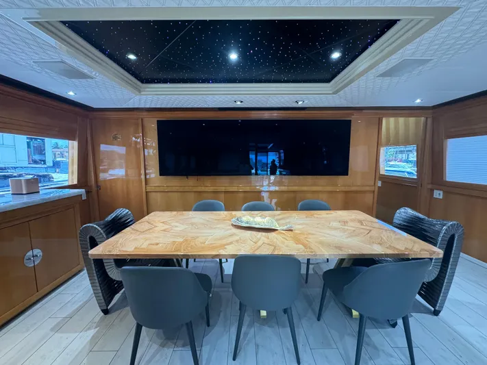  Yacht Photos Pics Luxurious dining area on 2000 Baglietto 116 yacht with elegant wood table and modern chairs.