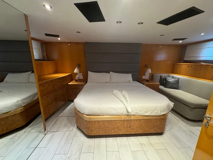  Yacht Photos Pics Luxurious bedroom interior on 2000 Baglietto 116 yacht with modern furnishings and cozy lighting.